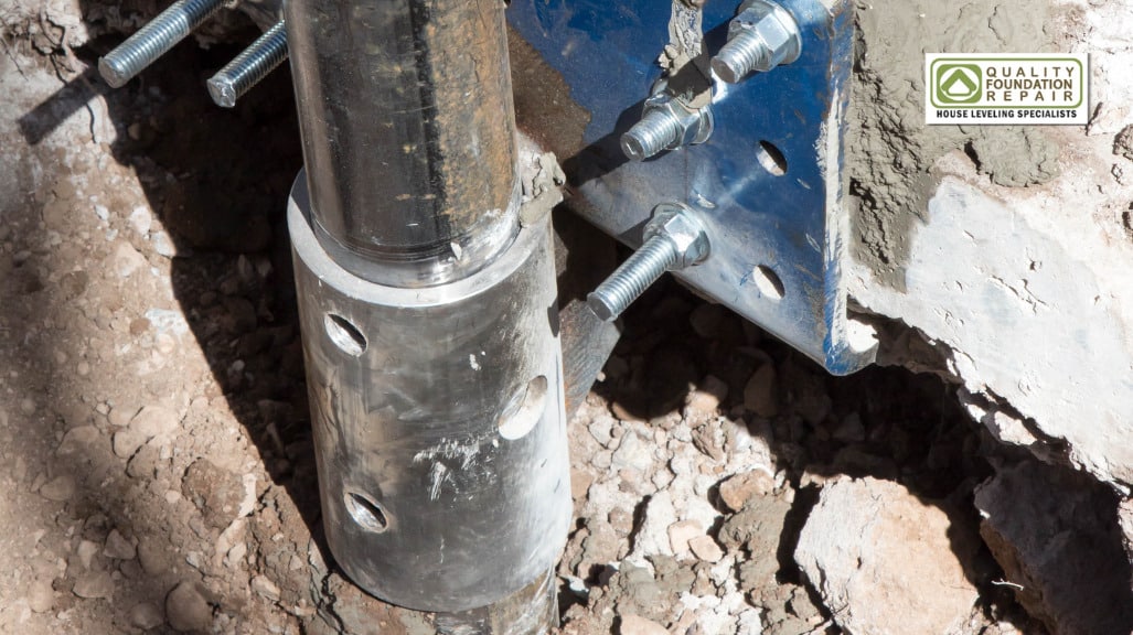 Quality Foundation Repair Austin steel push pier bolted to a foundation bracket during installation.