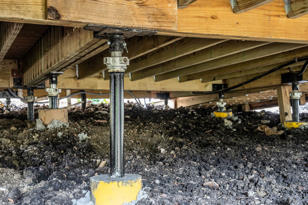 Quality Foundation Repair Austin adjustable pier set on a load pad beneath an exterior deck.