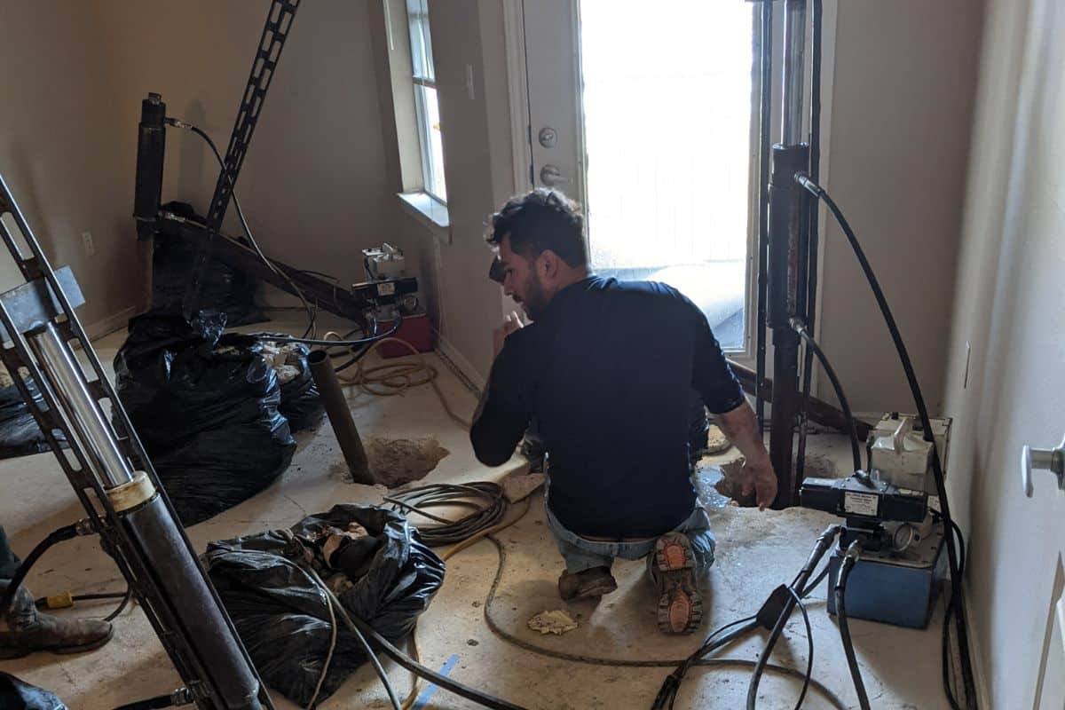 Quality Foundation Repair Austin running pier equipment inside a room during a repair.