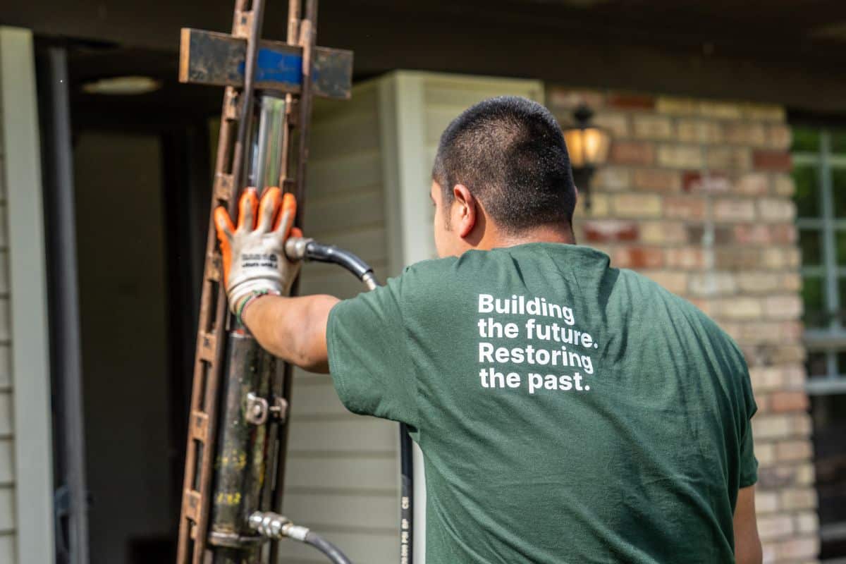Quality Foundation Repair Austin technician running equipment at a residential foundation repair.
