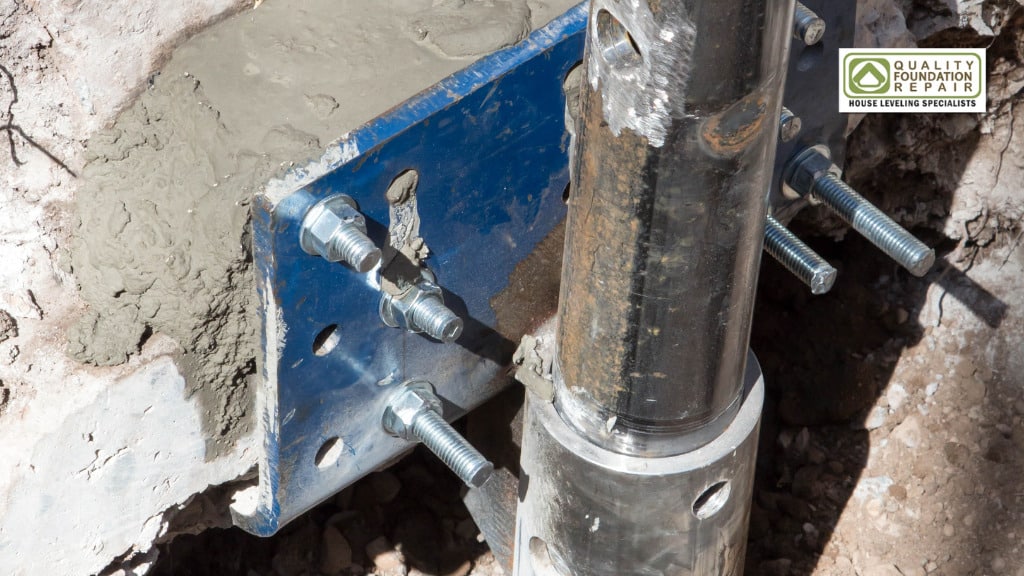 Quality Foundation Repair Austin installing a steel push pier foundation bracket and steel pier into the concrete foundation.