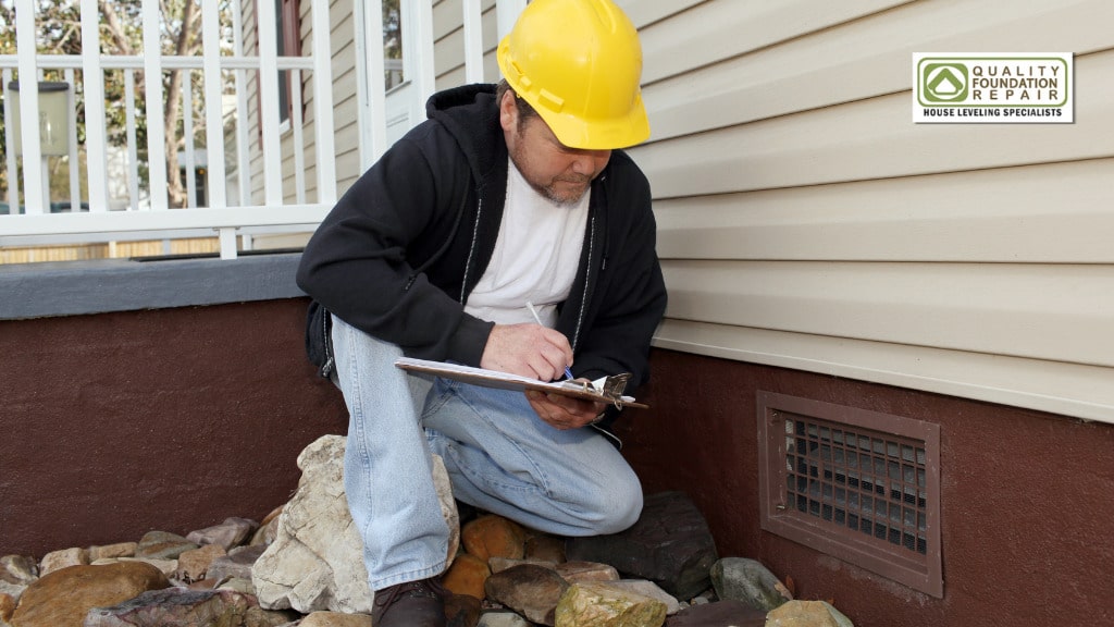 Quality Foundation Repair Austin technician recording findings during a home foundation inspection.