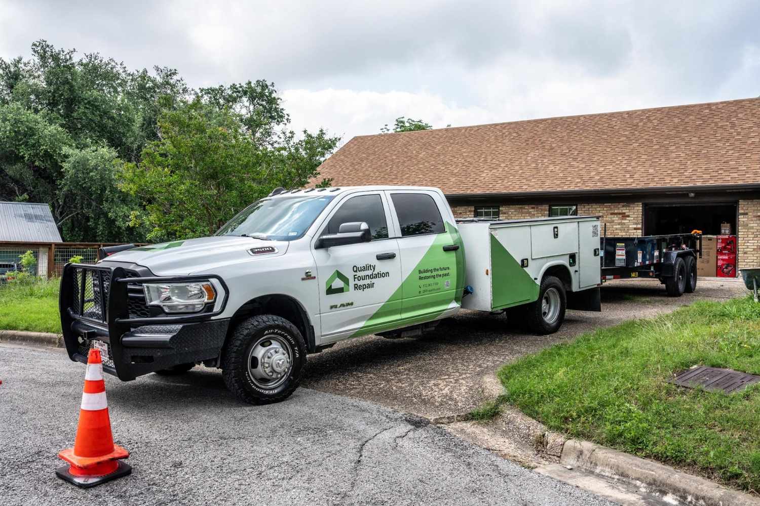 Quality Foundation Repair Austin service truck and trailer parked at a Central Texas home.