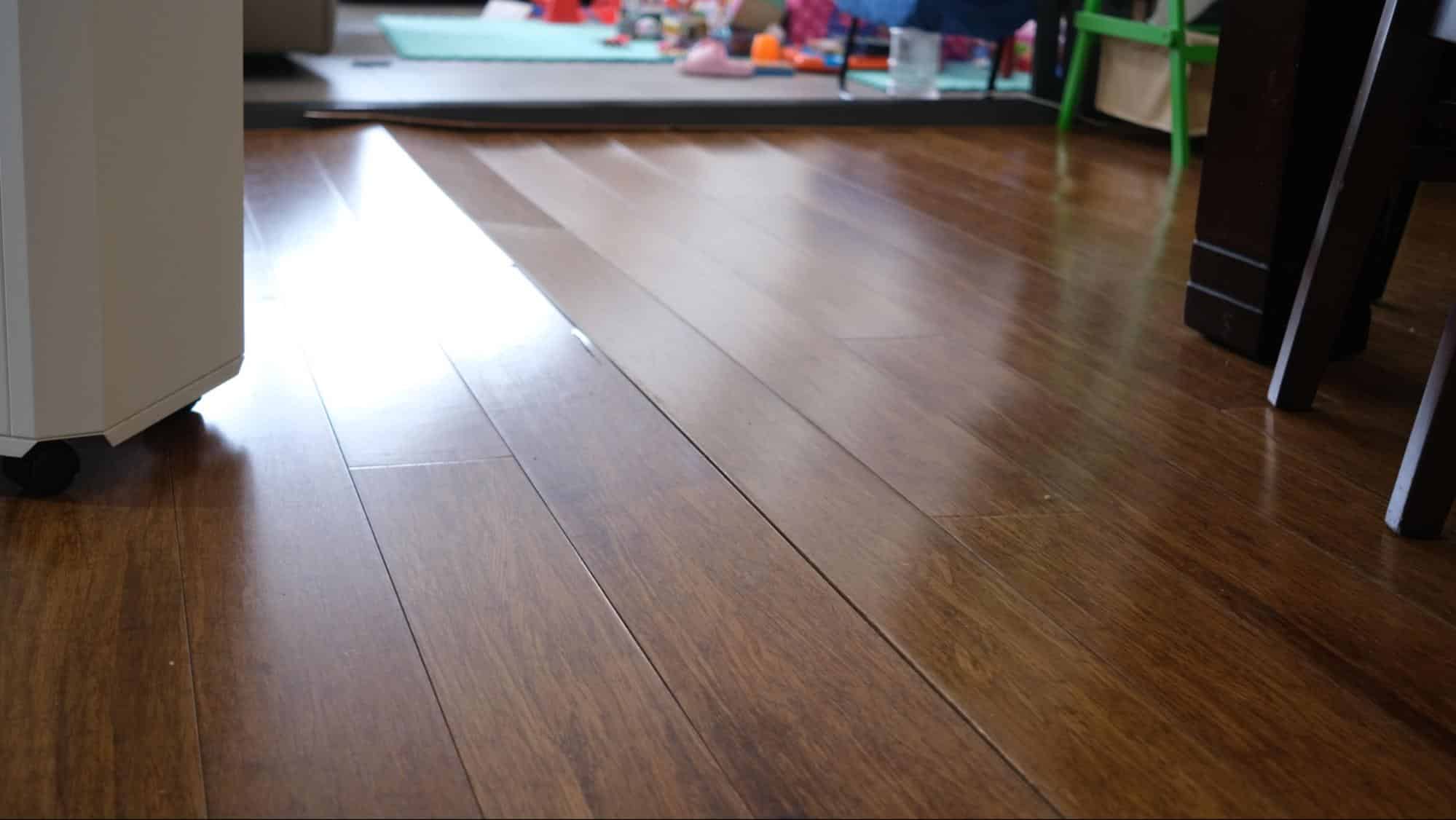 Quality Foundation Repair Austin inspecting uneven floors with visible floor sagging and gaps in wood floorboards.