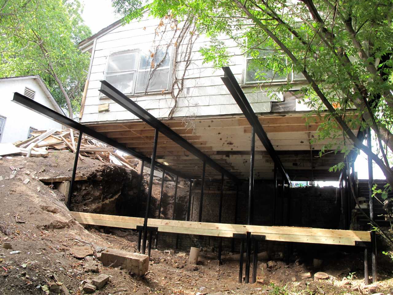 Quality Foundation Repair Austin steel I beams bracing a raised house during structural repair.