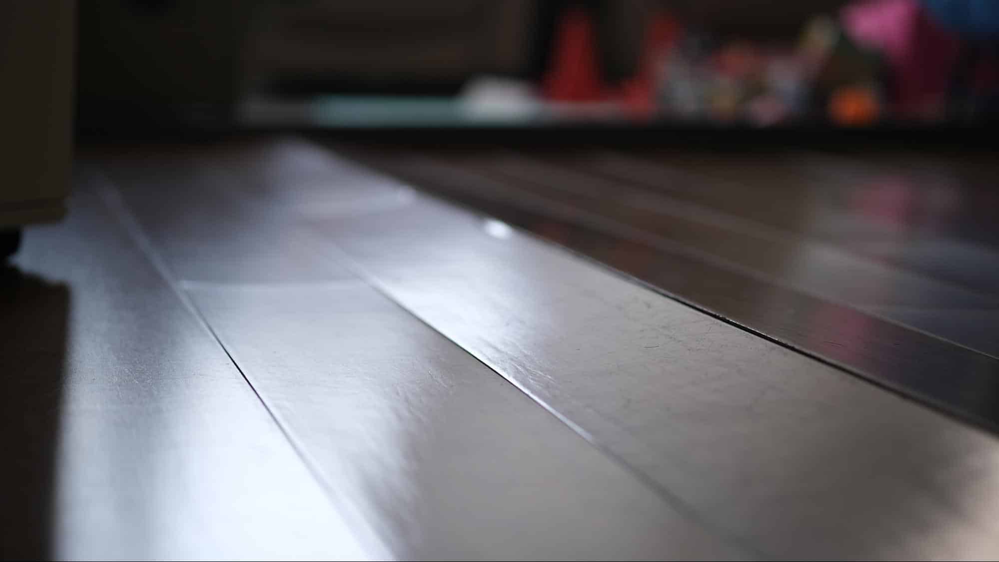 Quality Foundation Repair Austin inspecting uneven wooden floorboards showing signs of sagging.