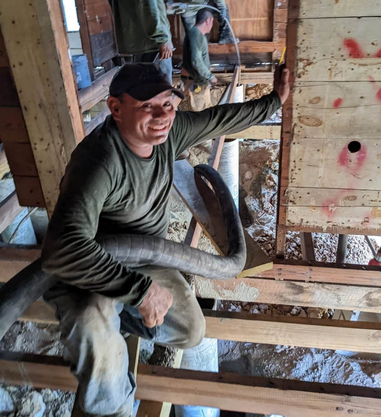 Quality Foundation Repair Austin team member smiling during structural crawl space repair work, reinforcing floor joists.