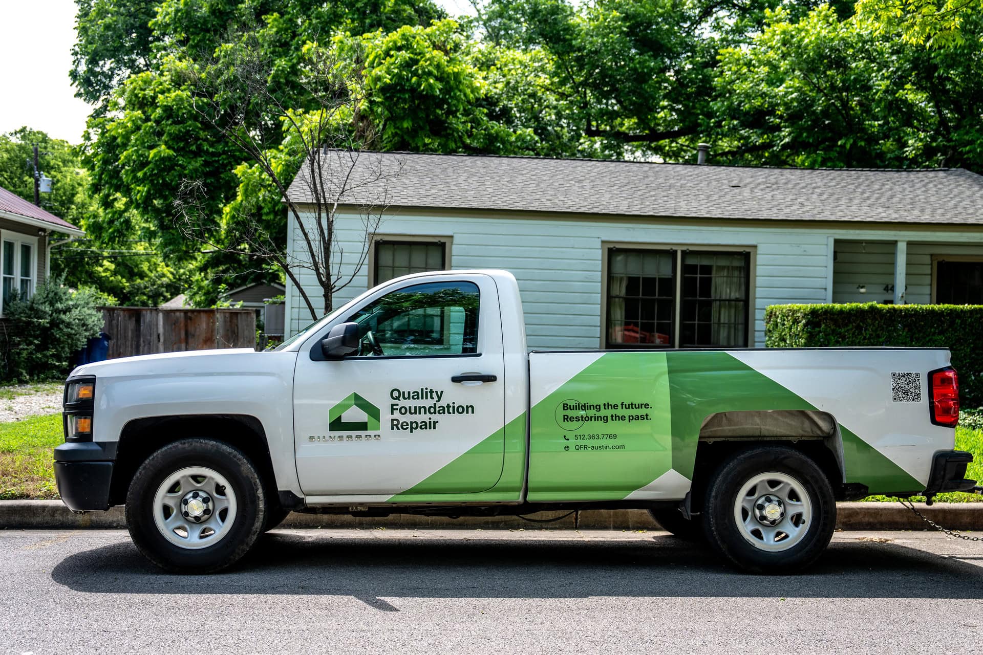 Quality Foundation Repair Austin branded pickup truck outside a customer's home in Austin.