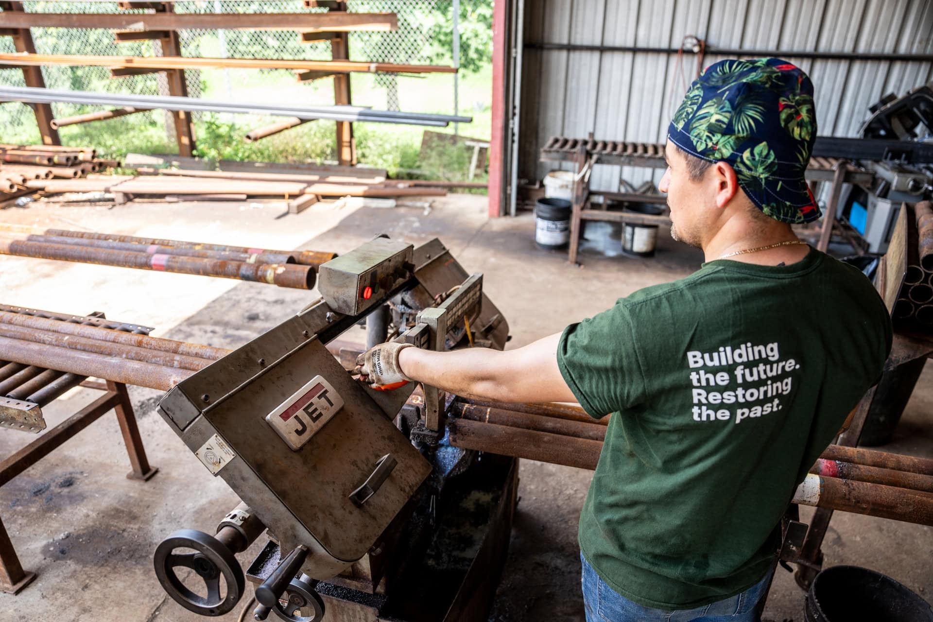 Quality Foundation Repair Austin team member in a workshop operating metal cutting equipment, demonstrating their dedication to in-house fabrication.