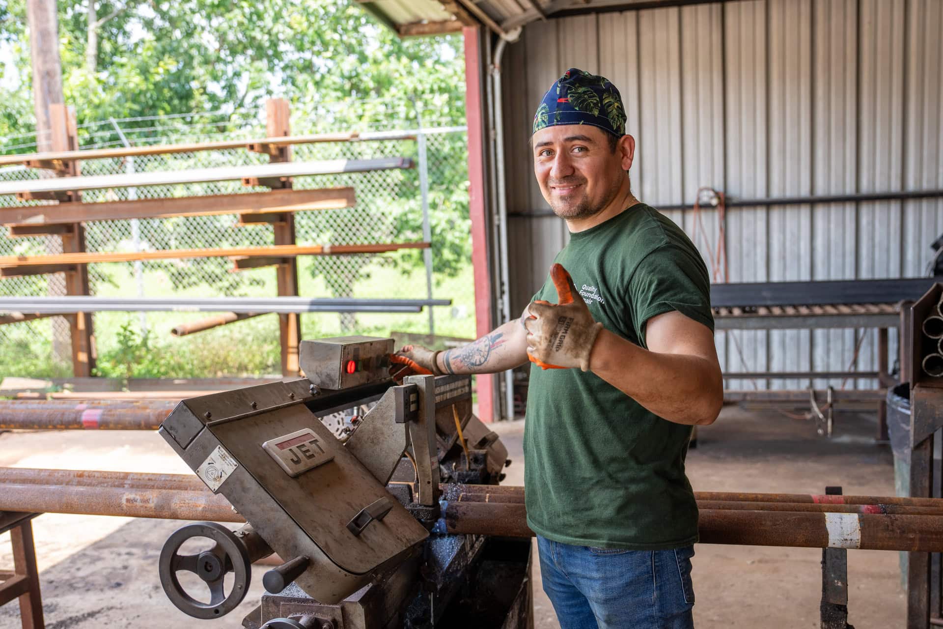 Quality Foundation Repair Austin team member cutting steel pipe to length on a workshop saw.