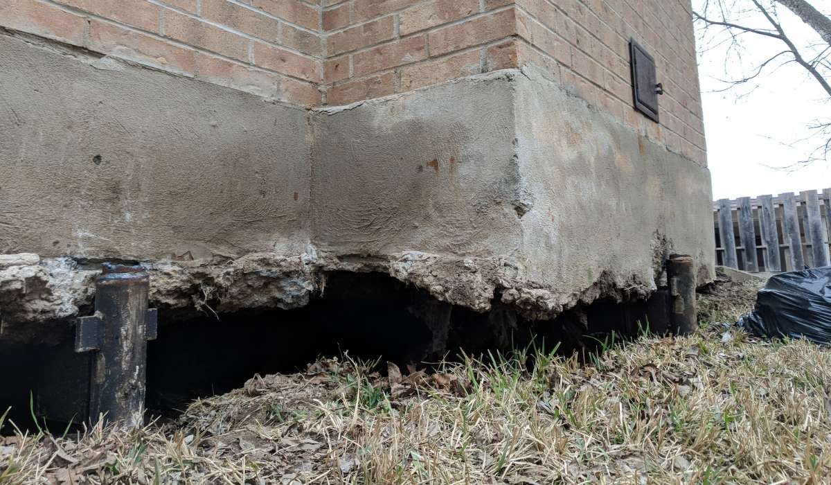 Quality Foundation Repair Austin inspecting crumbling foundation wall with exposed piers due to severe deterioration.