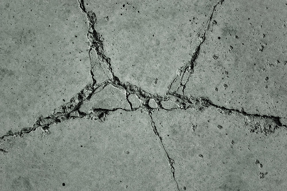 Quality Foundation Repair Austin inspecting severe cracks in a concrete foundation slab.