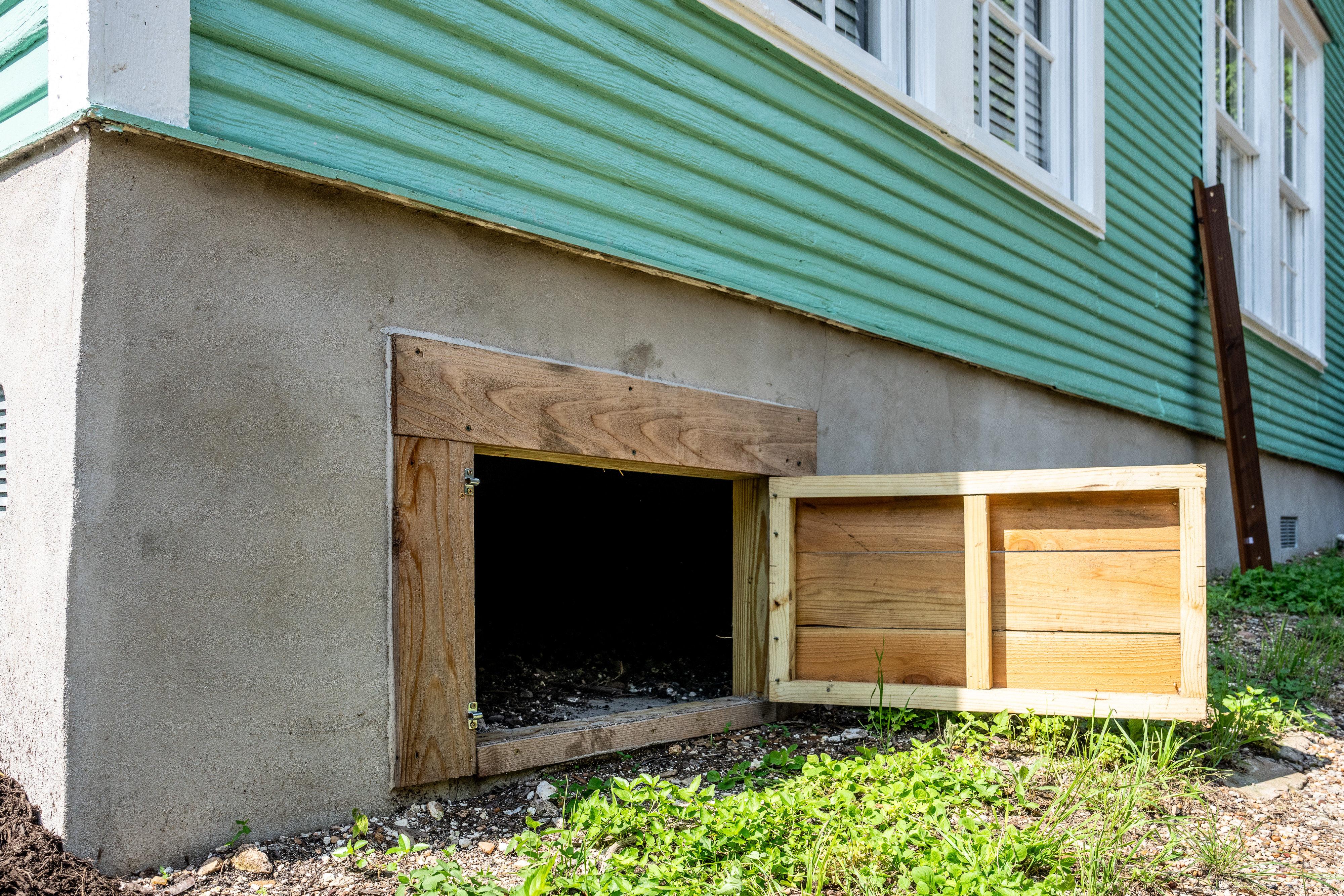 Quality Foundation Repair Austin installing a new crawl space access well with a wooden door.