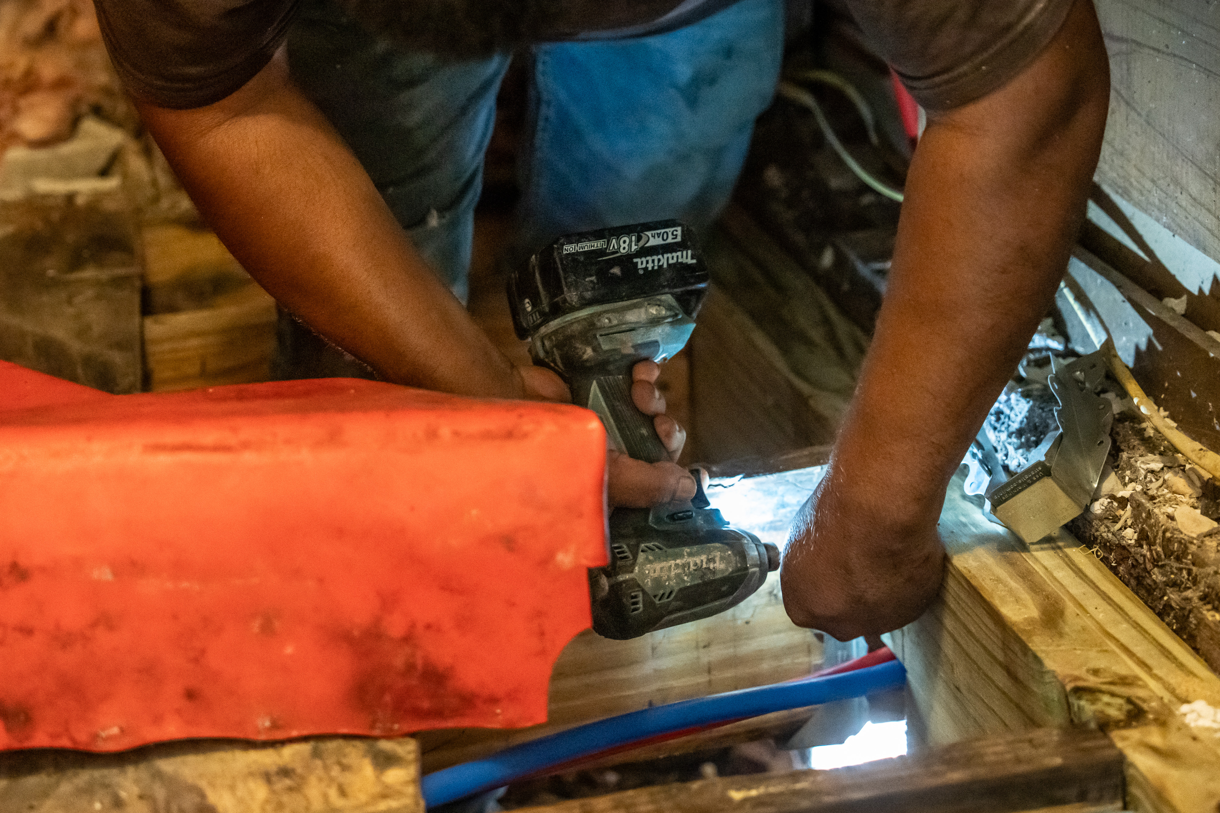 Quality Foundation Repair Austin technician installing structural hardware in a crawl space to reinforce wood joists.