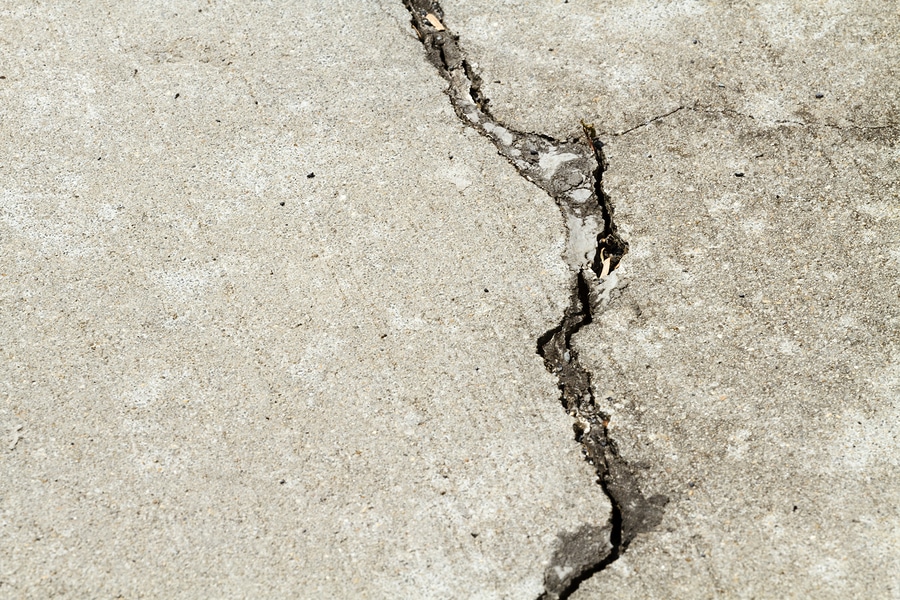 Ground Up Foundation Repair, Waterproofing and Concrete Leveling inspecting a prominent, jagged concrete floor crack.