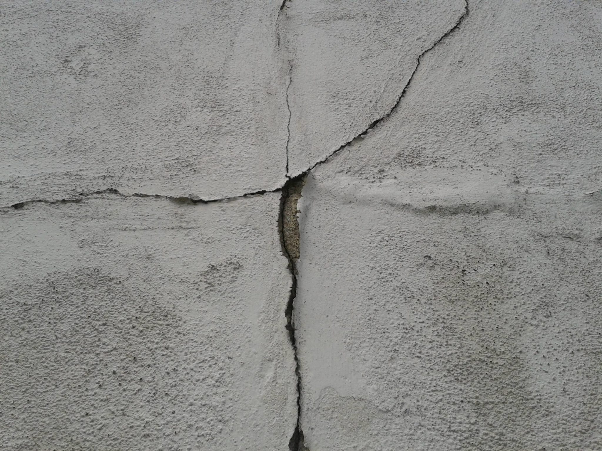 Ground Up Foundation Repair, Waterproofing and Concrete Leveling inspecting a prominent concrete wall crack indicating struct
