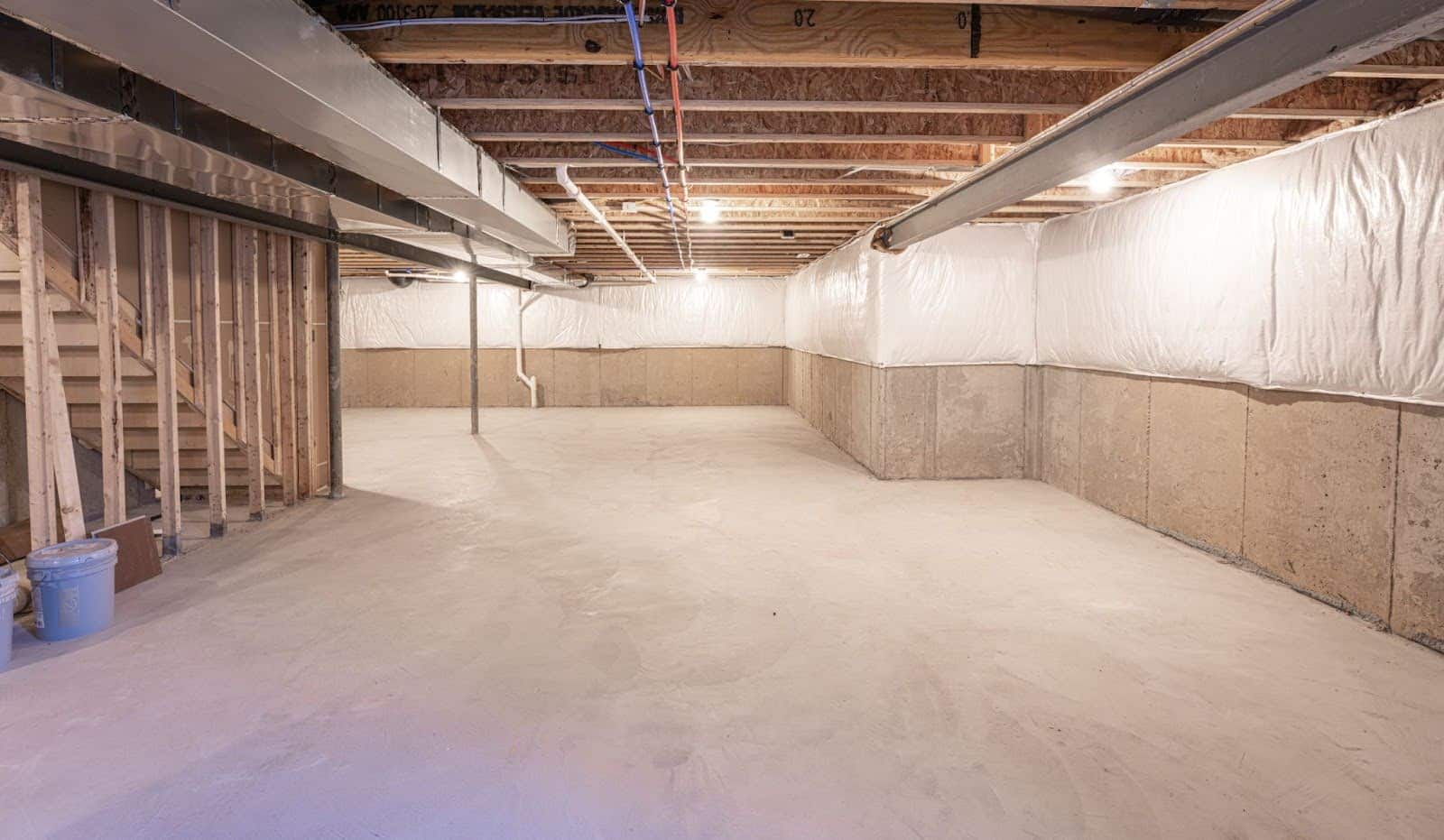 Ground Up Foundation Repair, Waterproofing and Concrete Leveling installing vapor barrier and preparing a basement for finish