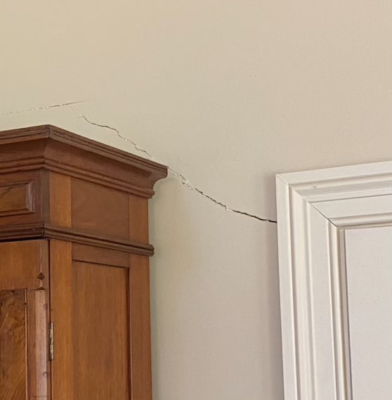 A diagonal drywall crack above a door frame.
