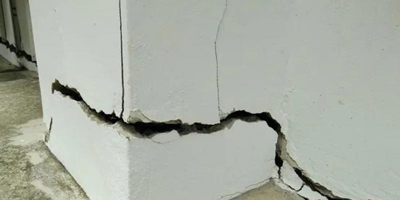 Inspecting a severe foundation crack and the surrounding structural damage.