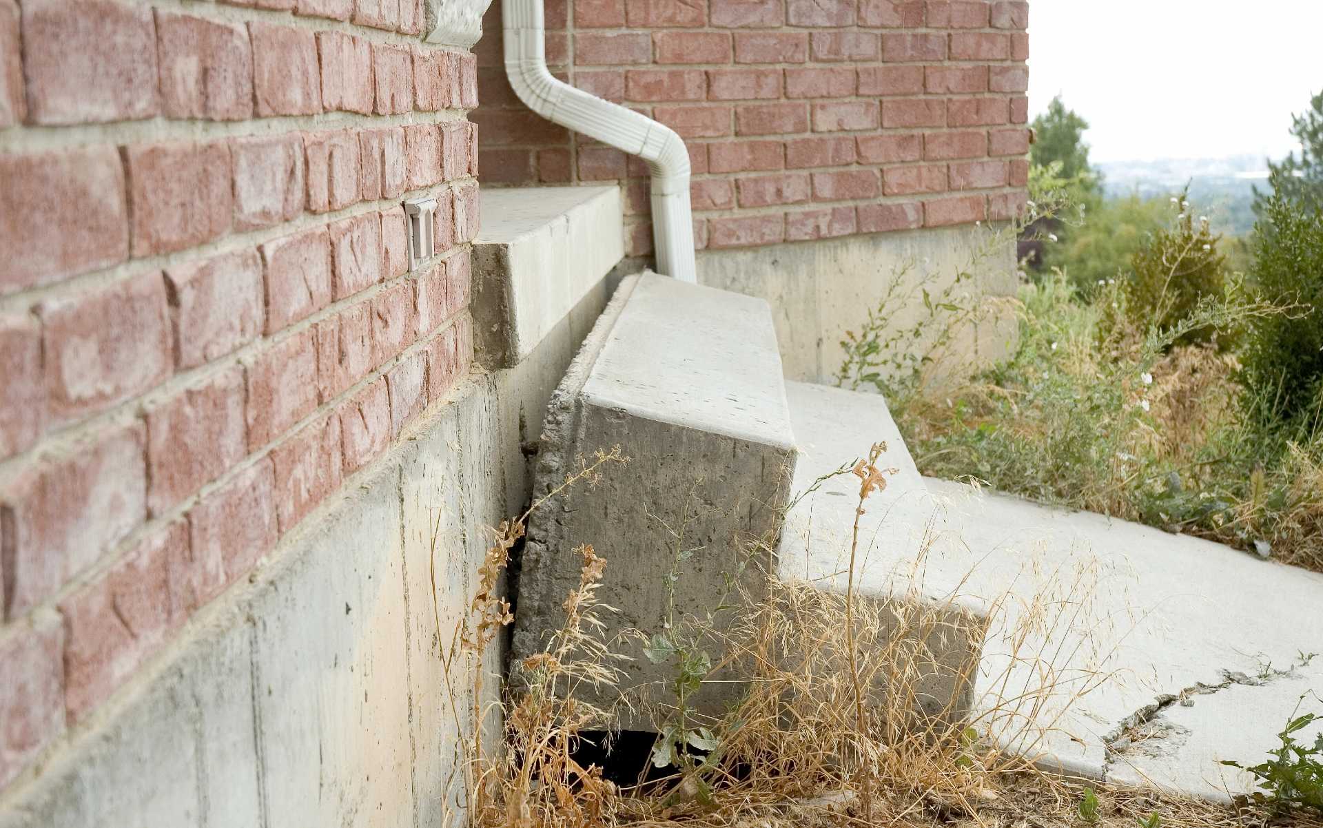Sunken concrete steps showing foundation settlement.