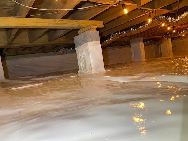 Ground Up Foundation Repair, Waterproofing and Concrete Leveling installing a clean white vapor barrier in an encapsulated cr