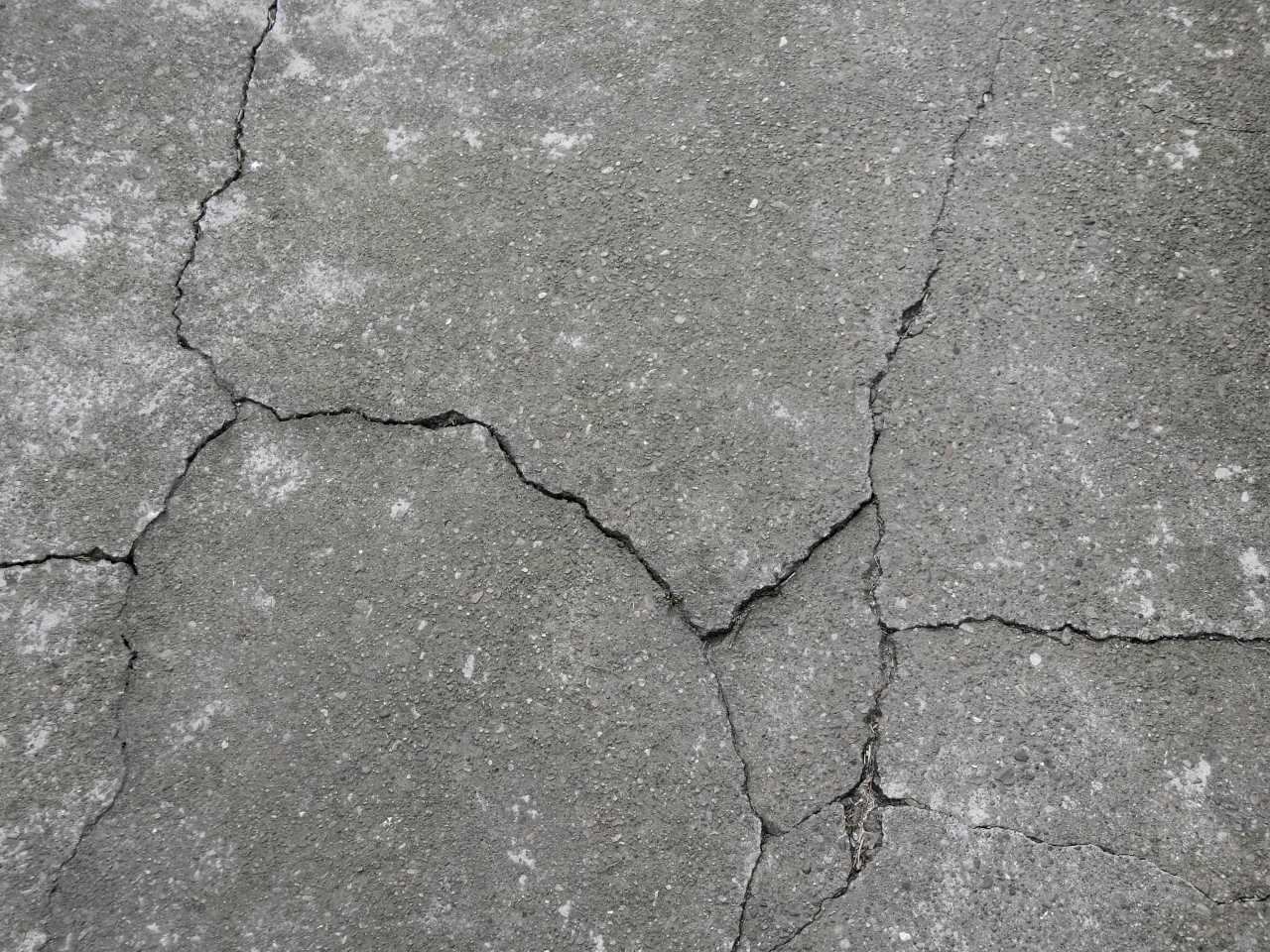 Ground Up Foundation Repair, Waterproofing and Concrete Leveling inspecting concrete floor cracks in a driveway or patio surf
