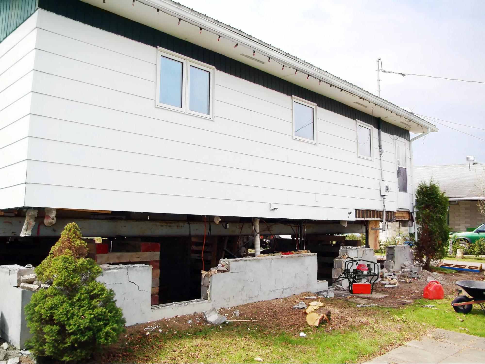 Ground Up Foundation Repair, Waterproofing and Concrete Leveling performing house lifting for foundation crack repair and str
