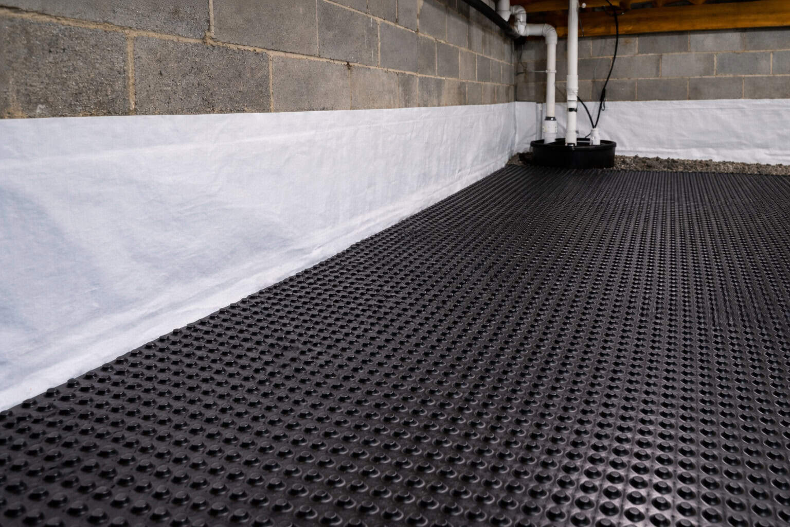 Interior water management system installed against a concrete block wall to stop groundwater seepage.