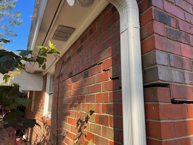 Severe diagonal cracks across an exterior brick wall.