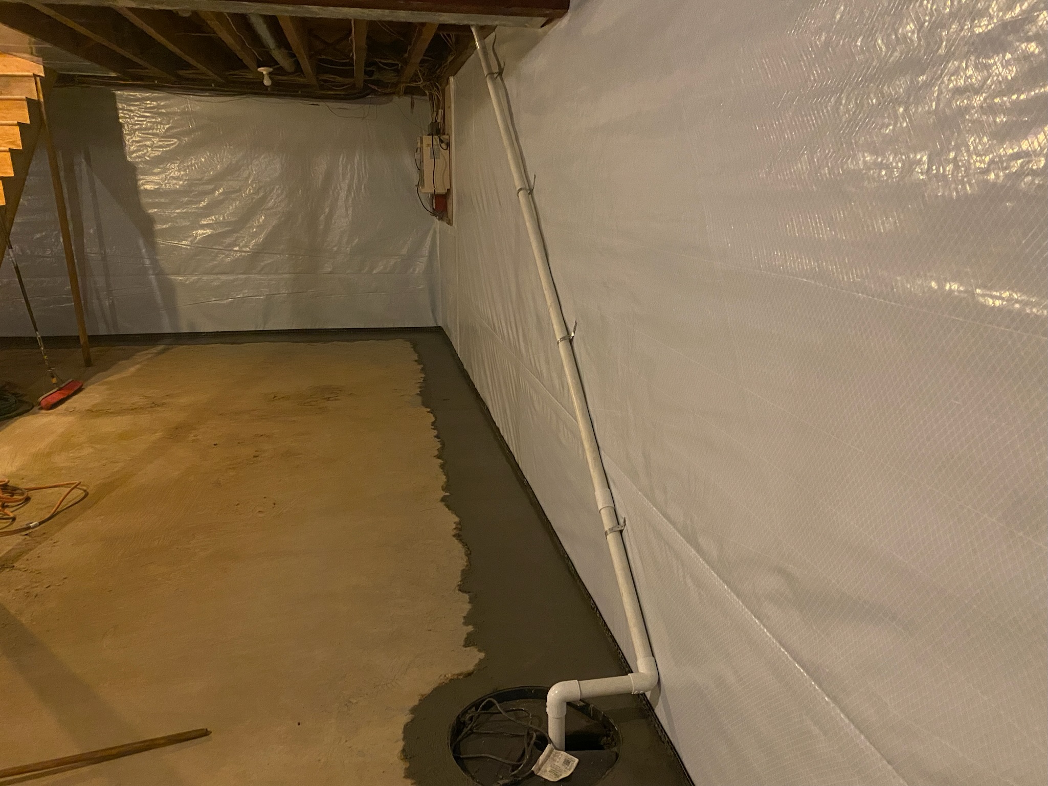 Liner and drain line along an encapsulated crawl space wall