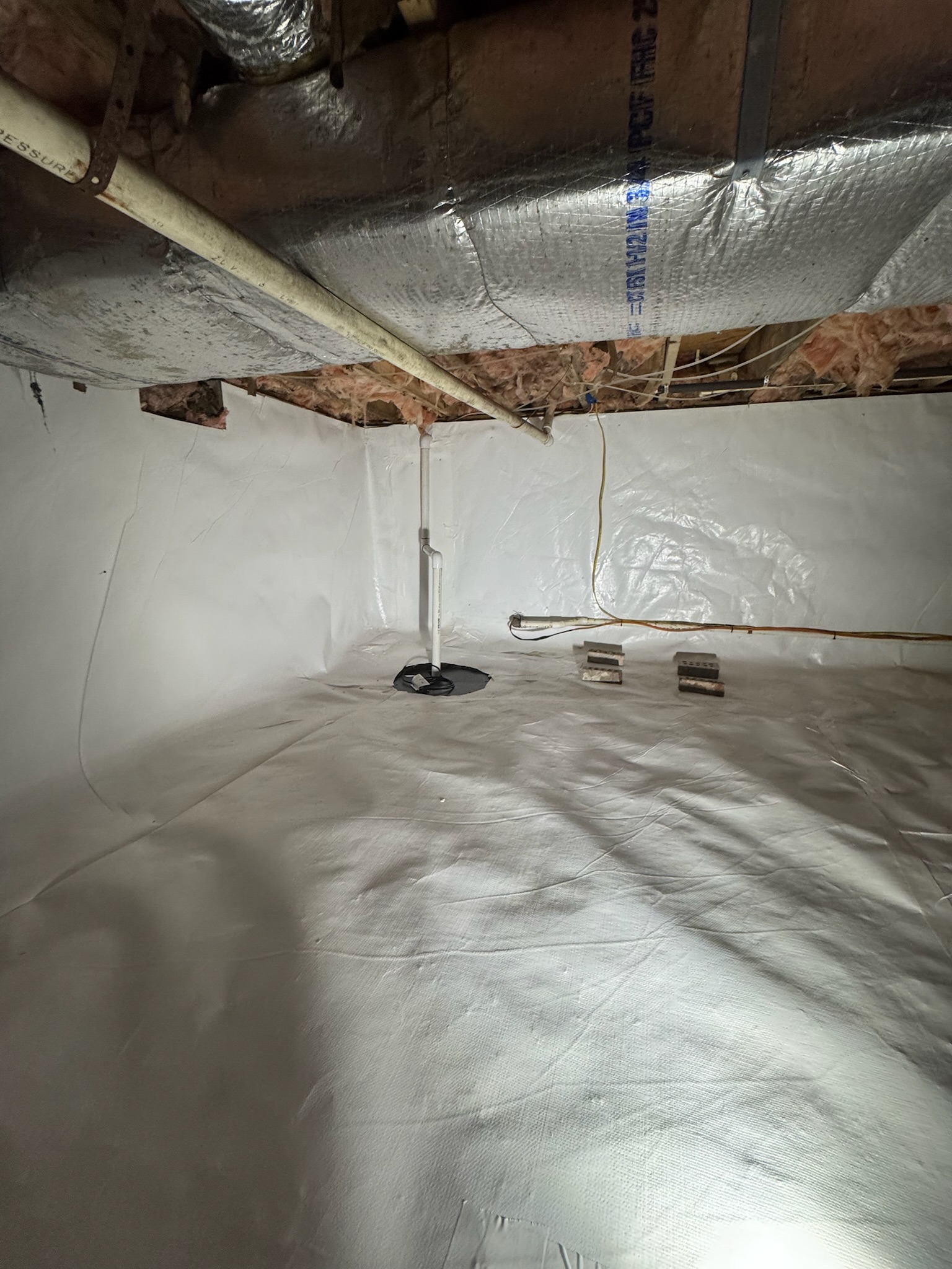 Oriole Basement Waterproofing installing a sump pump and vapor barrier in a clean crawl space.