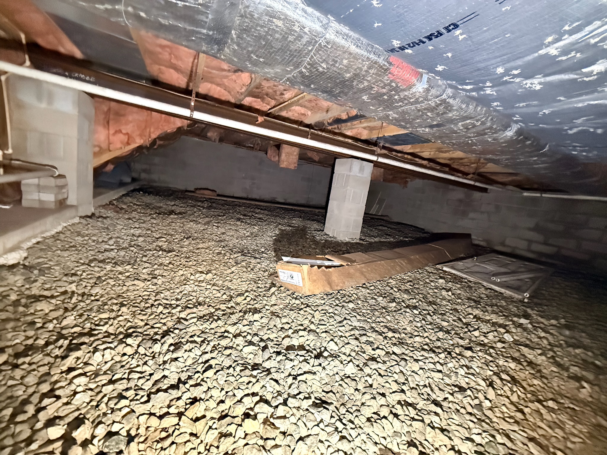 Unfinished Maryland crawl space with gravel floor, exposed insulation, and ductwork