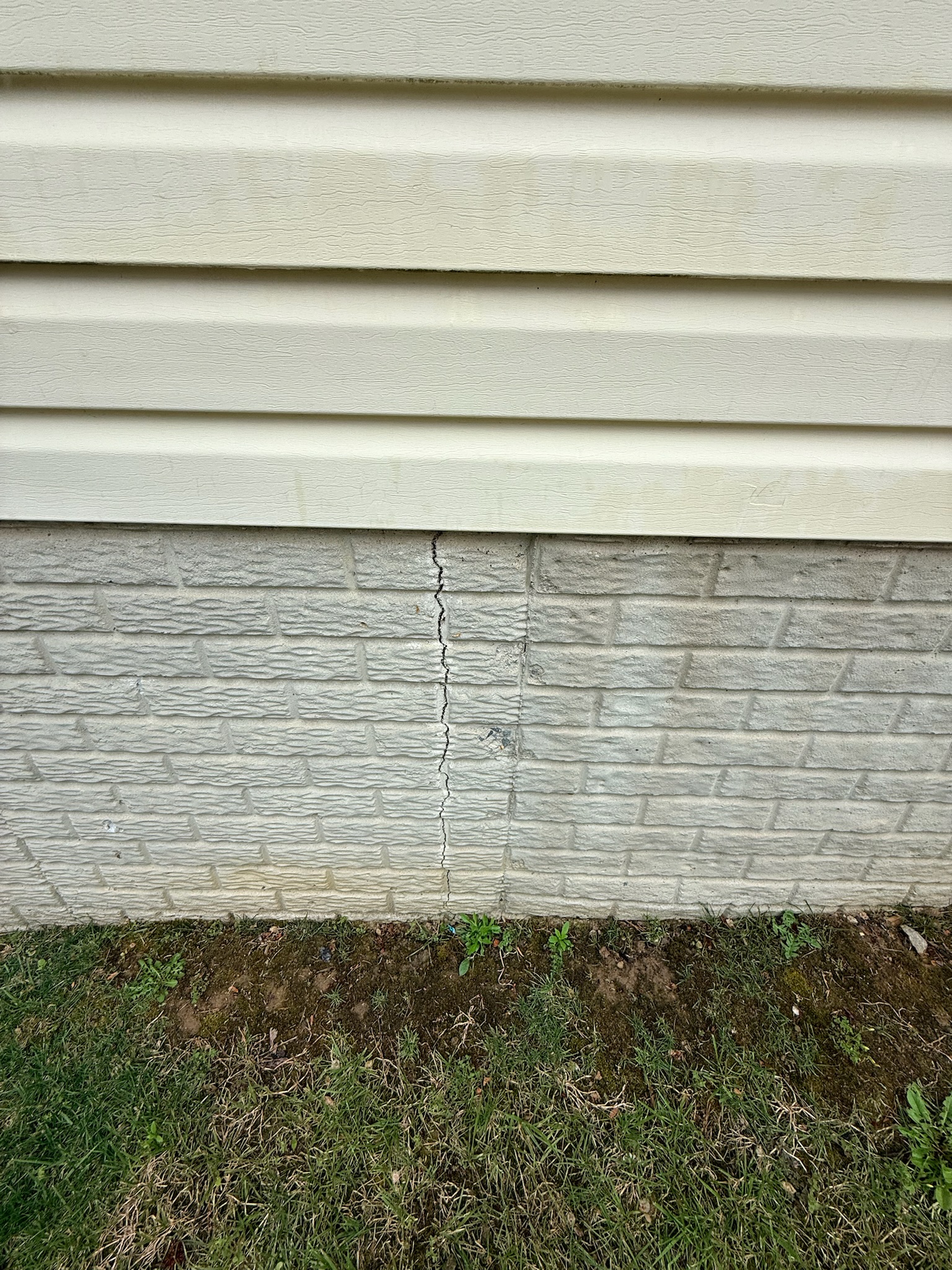 Cracked brick in a foundation wall showing advanced structural stress in a Maryland home