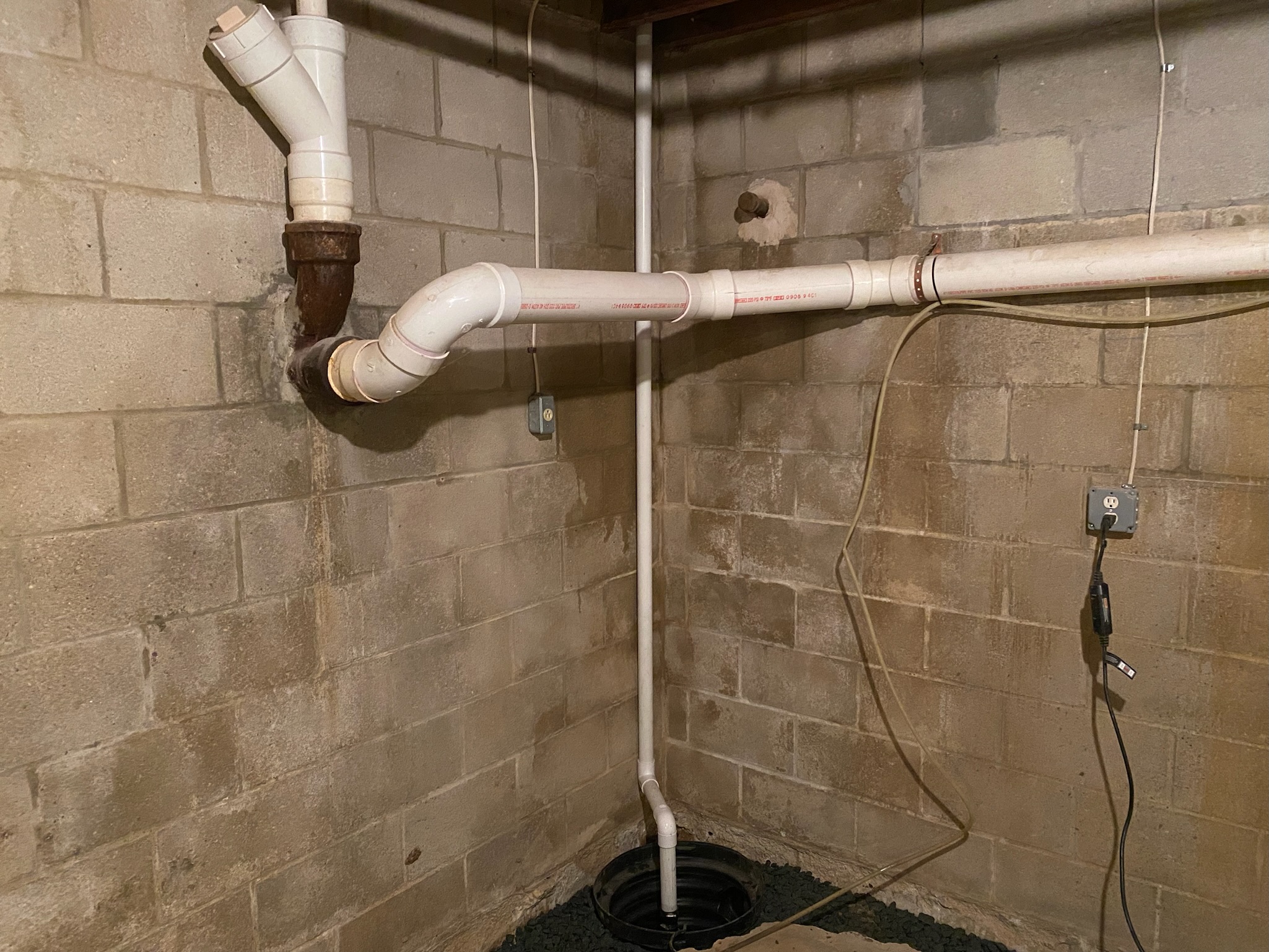 Sump pump and visible water stains on concrete walls found during an inspection