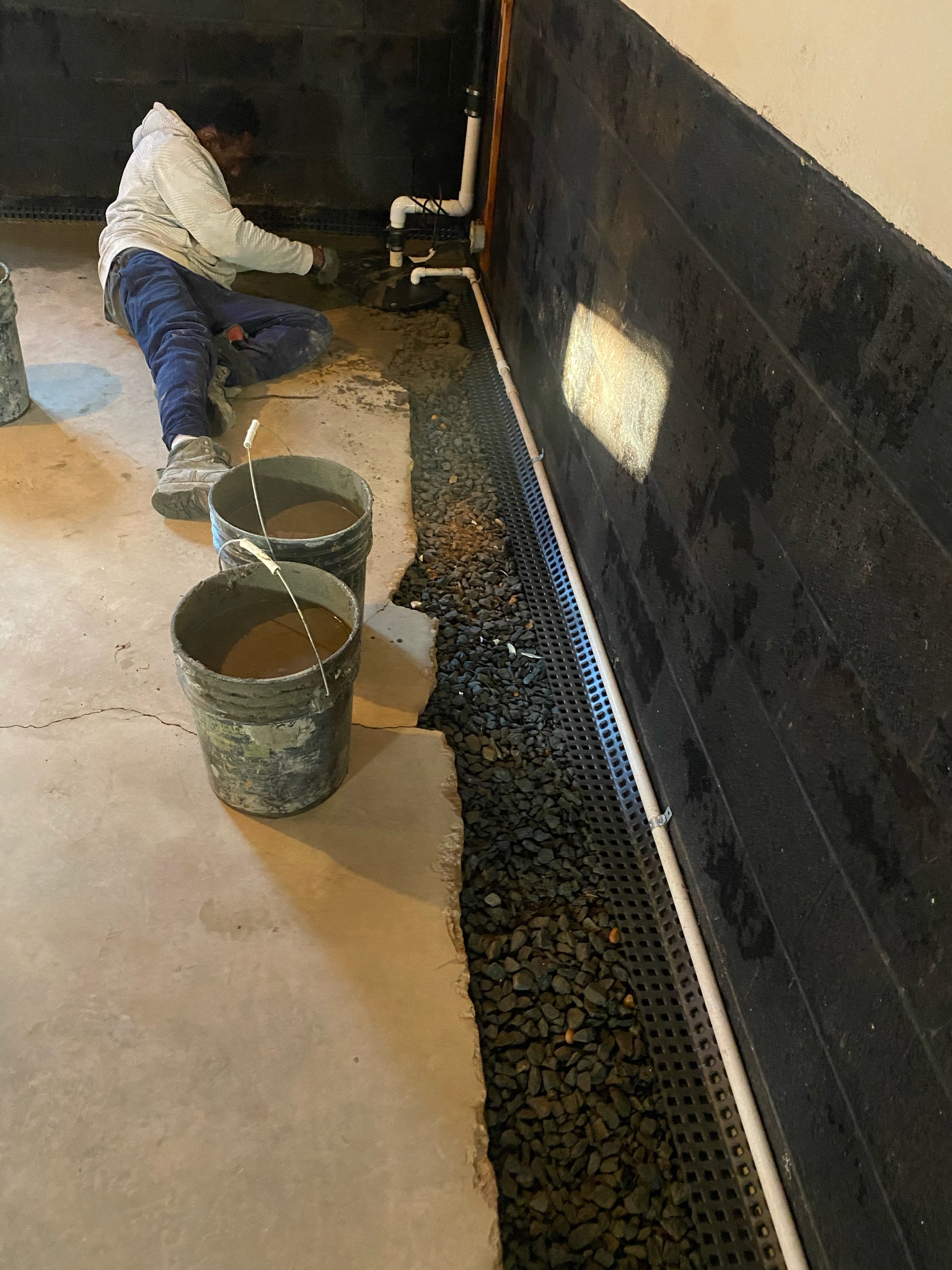 OBW technician inspecting sump pump basin during assessment