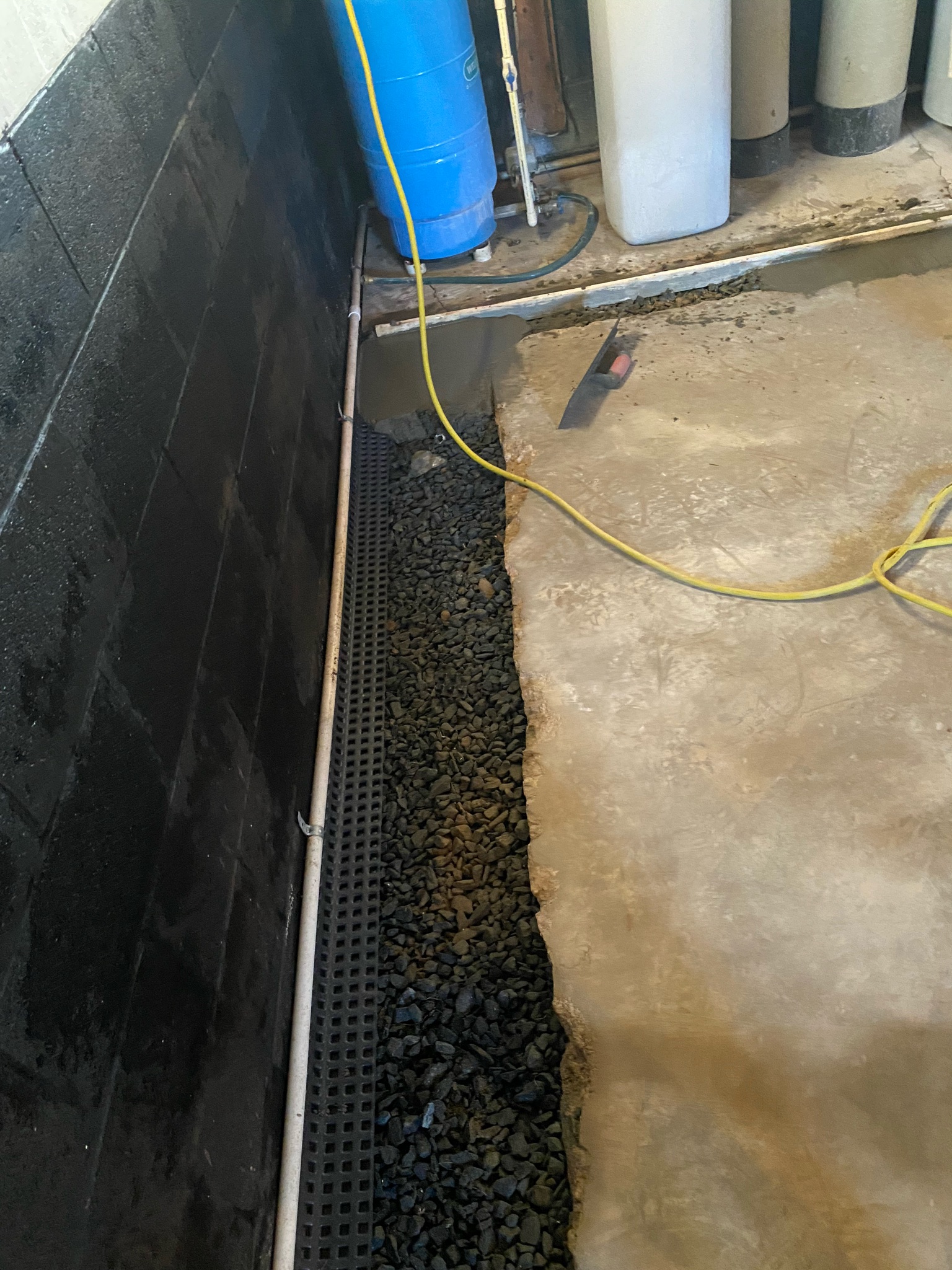 Interior perimeter drainage system with gravel fill installed in a Maryland basement