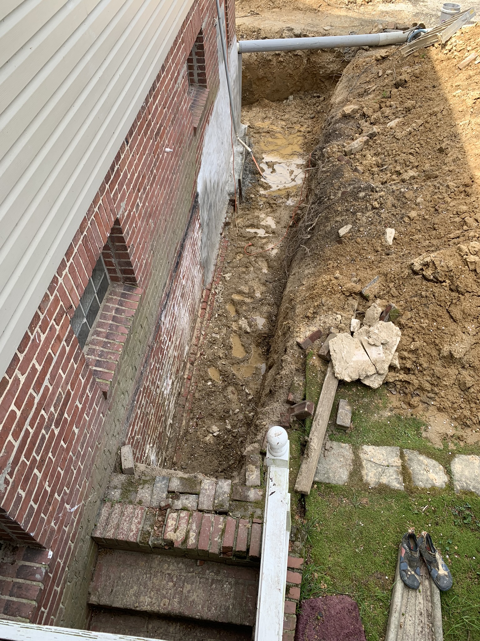 Oriole Basement Waterproofing crew preparing a Maryland foundation for exterior waterproofing with an excavated trench