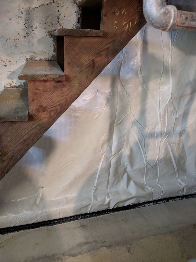 Dimple-board drainage matting installed on basement foundation wall