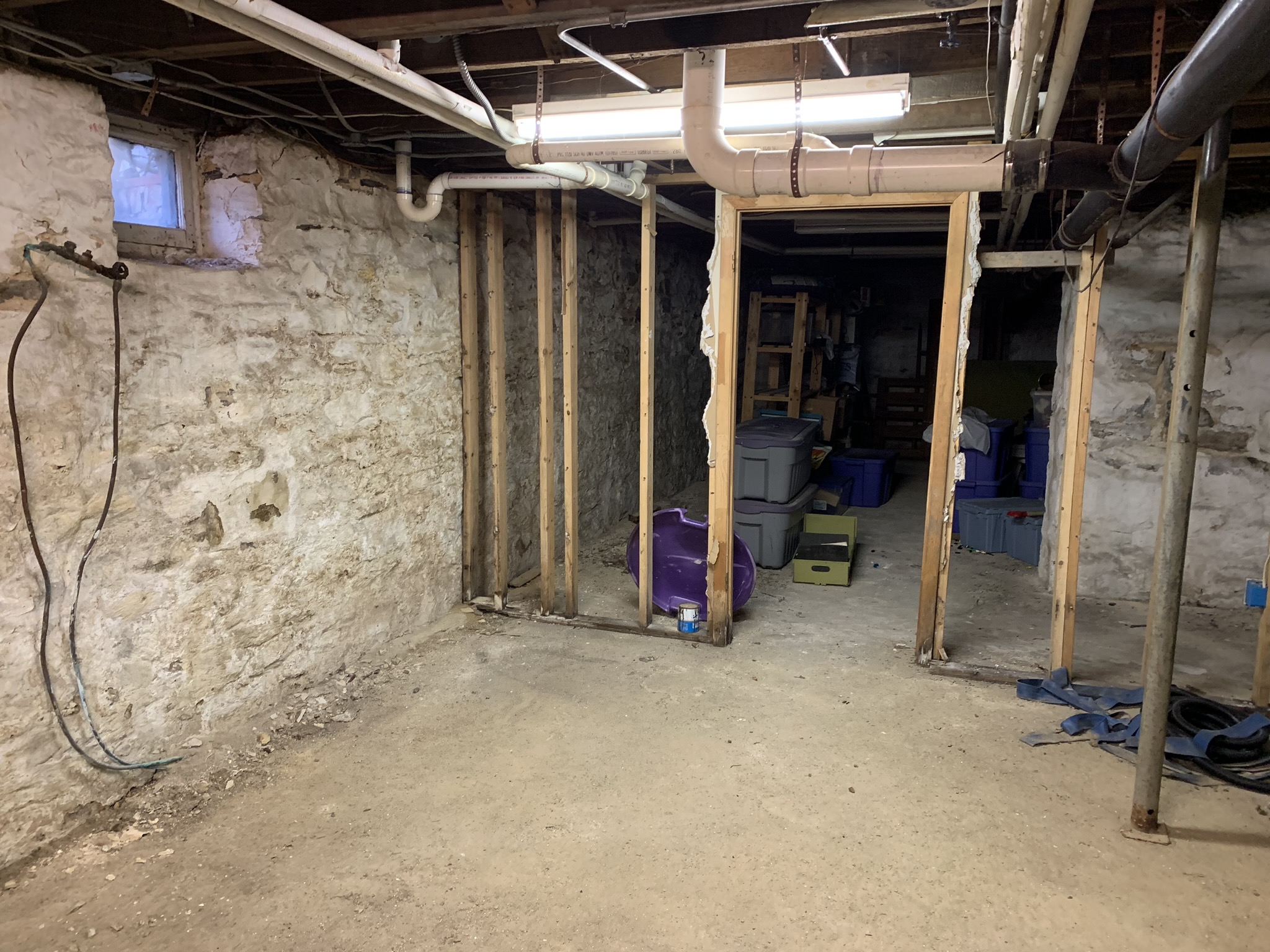 Unfinished Maryland basement prepared for waterproofing ahead of a conversion project