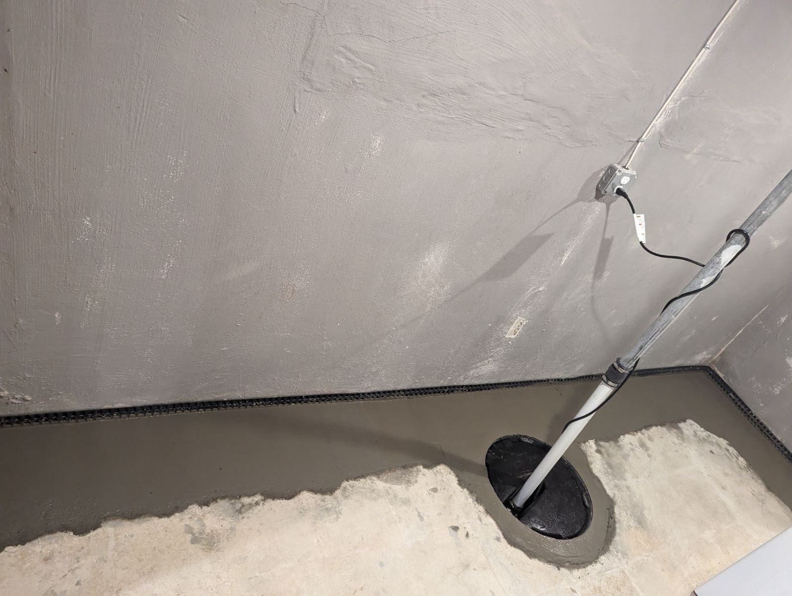 commercial-grade sump pump installation connected to interior drainage system