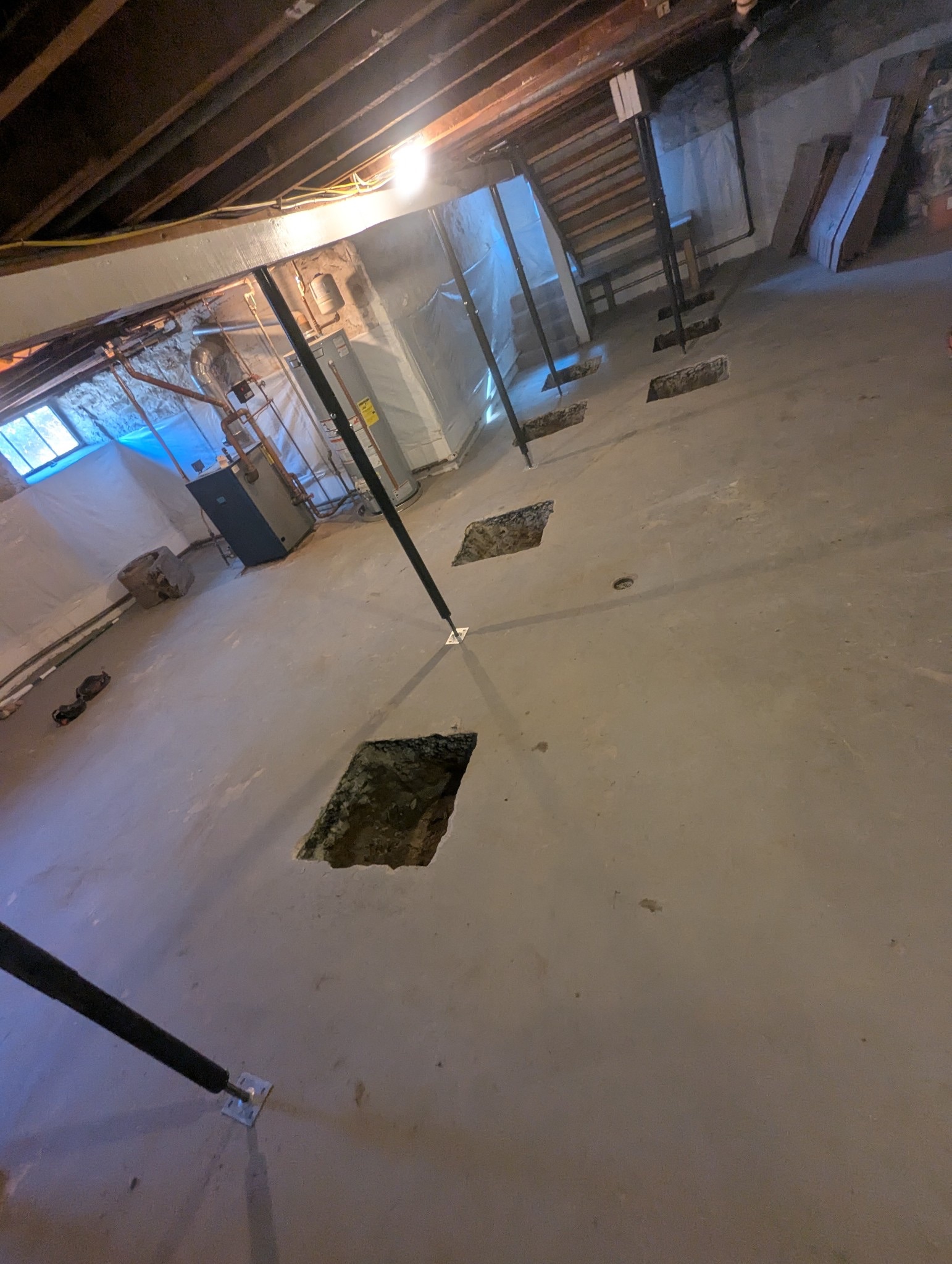 Concrete slab with patched cutouts and a steel support column