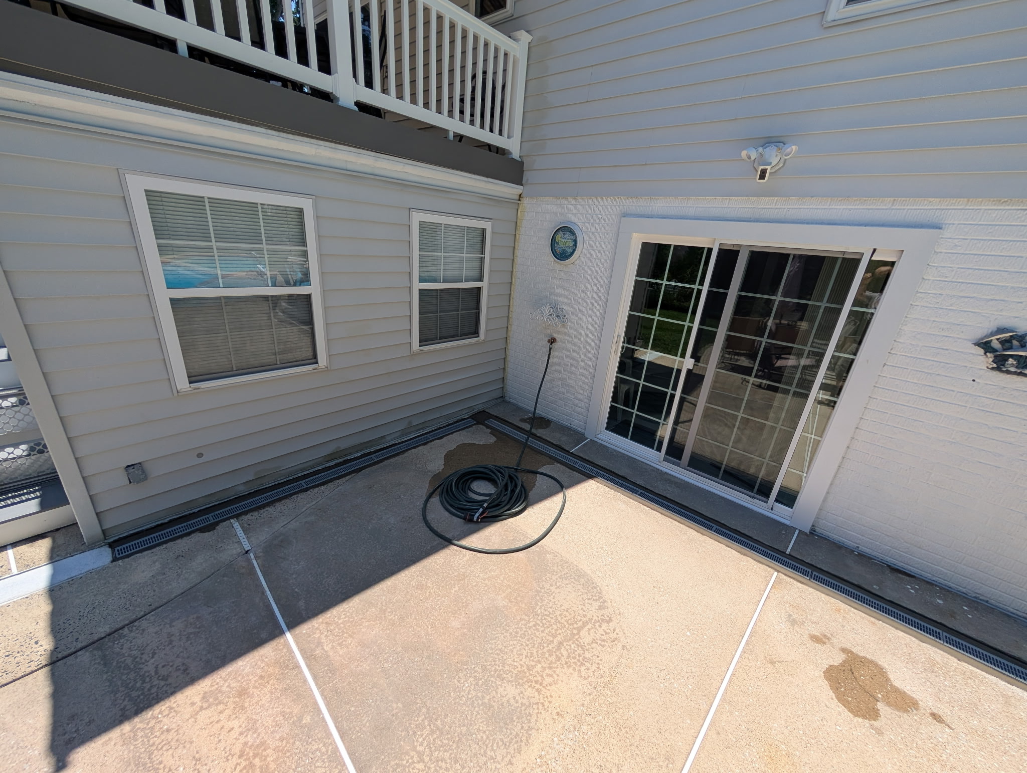Exterior drainage system installed along a Maryland house foundation and concrete patio