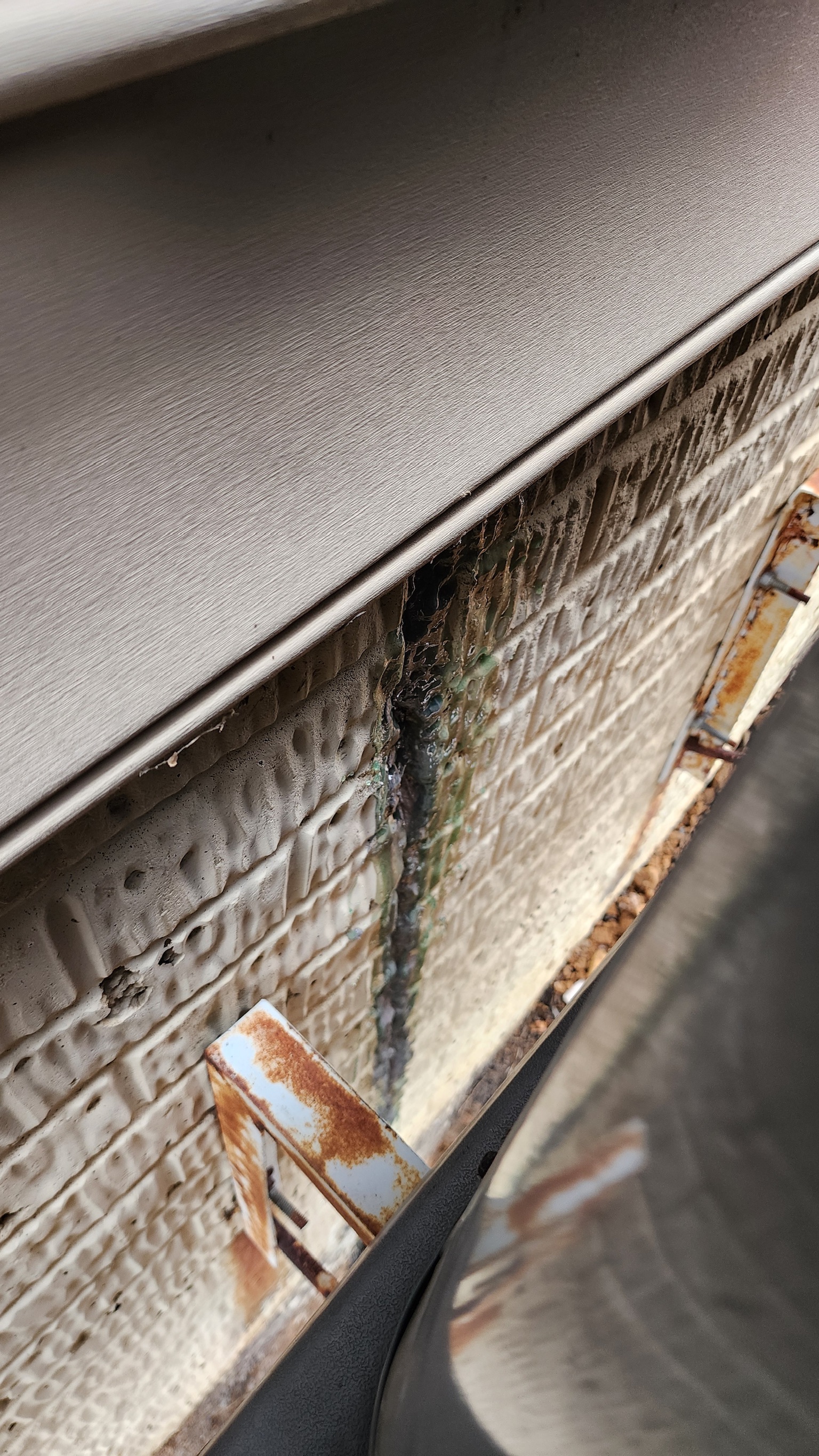 Oriole inspector examining a vertical crack in a block foundation