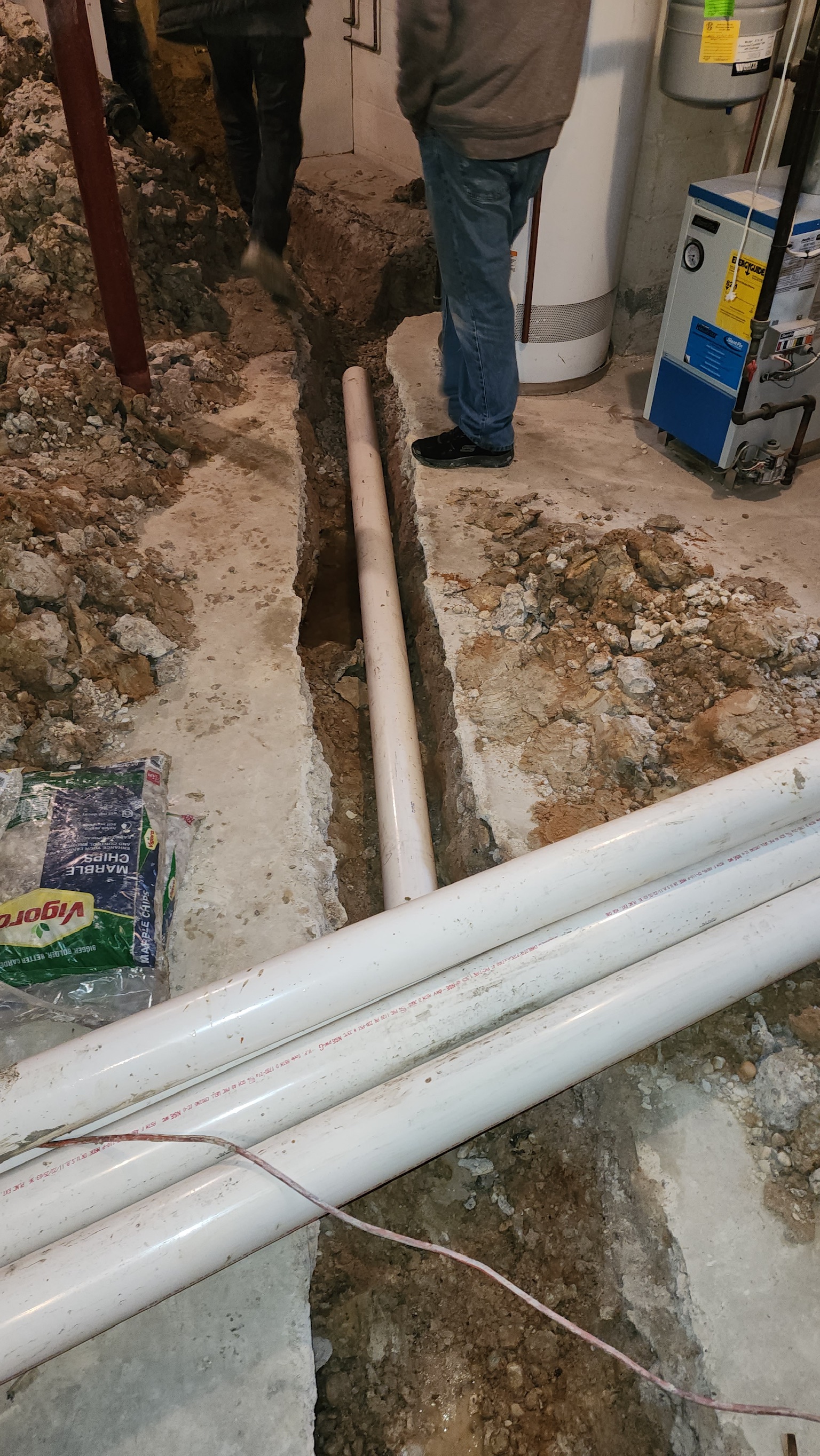Oriole crew setting drain lines in an open interior trench