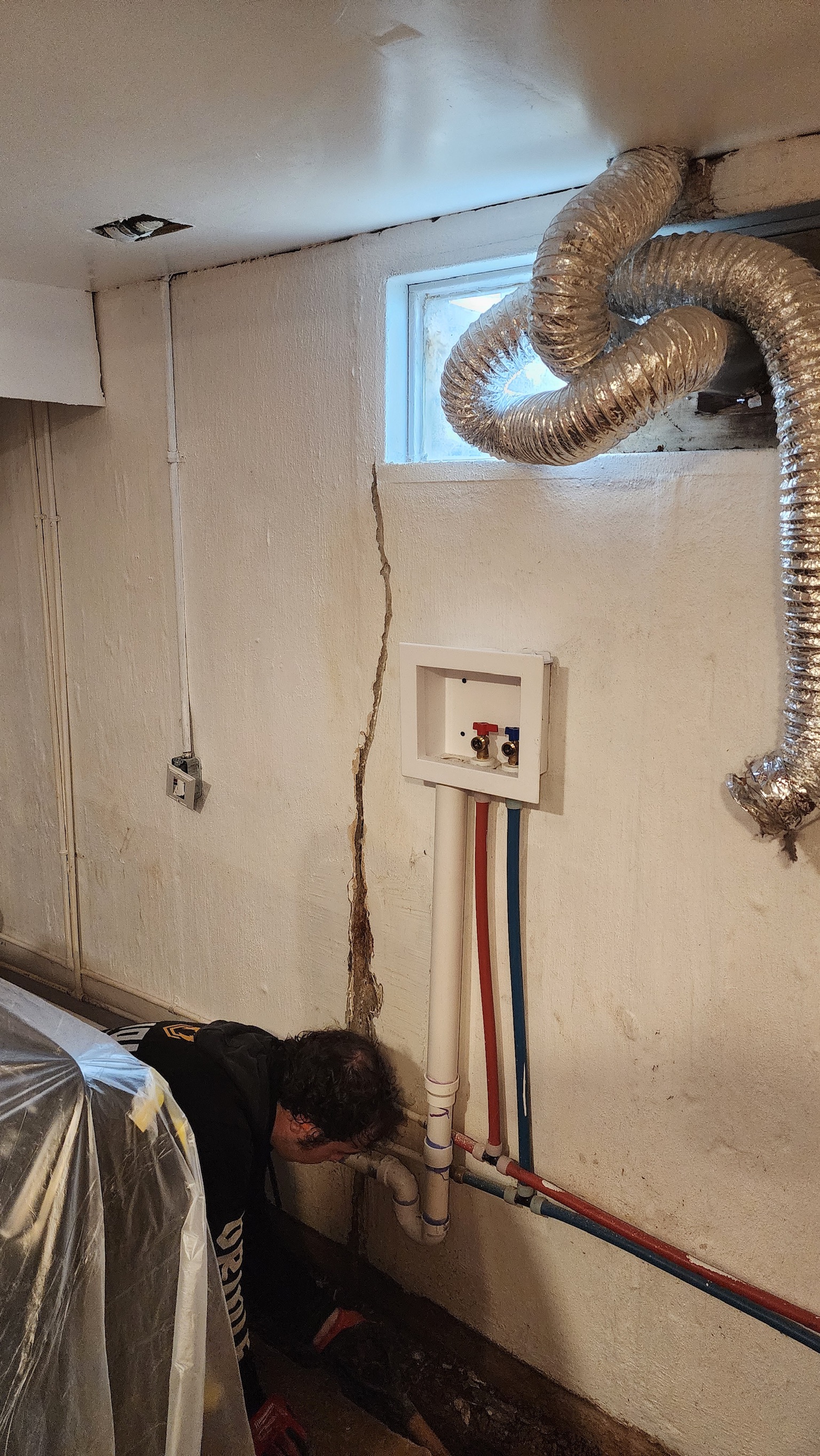 OBW technician inspecting vertical crack in Maryland block basement wall