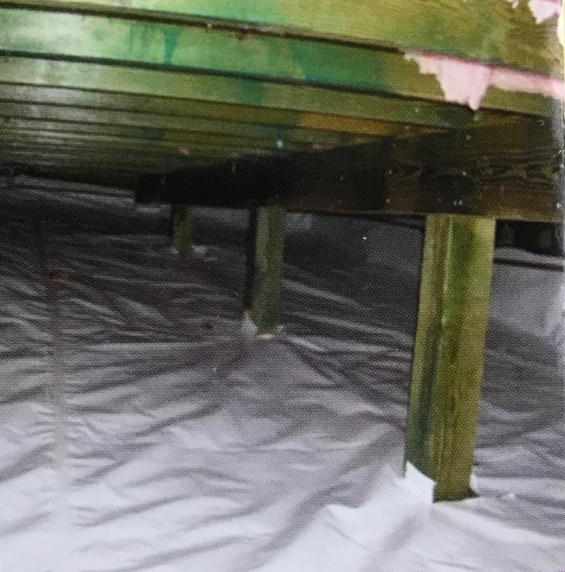 Sealed white vapor barrier installed under wooden joists after crawl space encapsulation