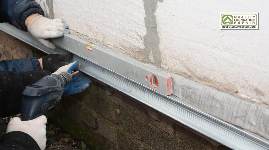 Quality Foundation Repair Austin checking a stem wall for level during a foundation repair.