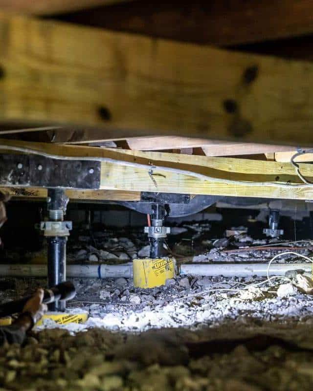 Quality Foundation Repair Austin technician checking Adjust-A-Piers during a crawl space visit.
