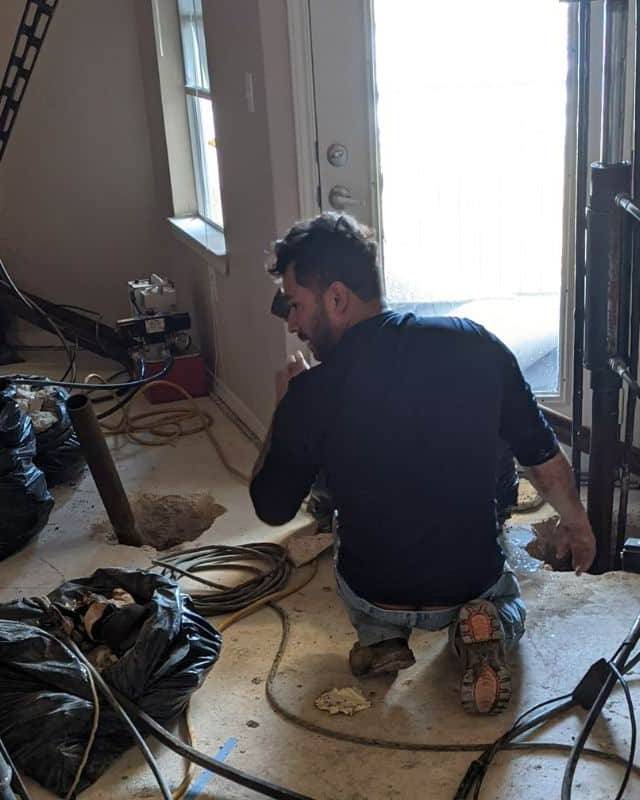 Quality Foundation Repair Austin team member running pier equipment during an interior repair.