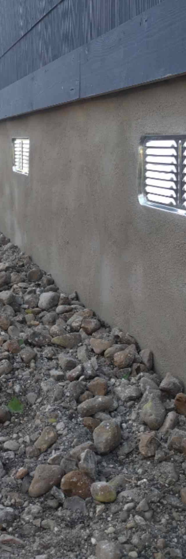 Quality Foundation Repair Austin installing crawl space vent covers on an exterior foundation wall.